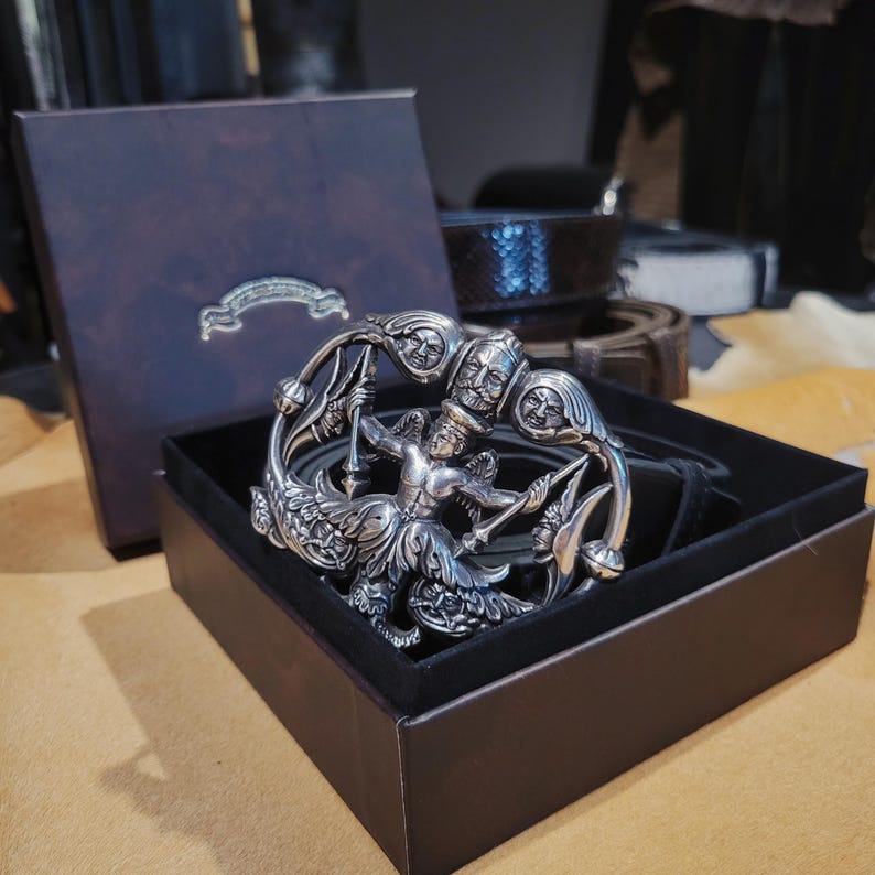 May include: A white ceramic mug with a black handle and the text "But First, Coffee" in a bold, black font. The mug is set against a neutral background, highlighting its simple design.