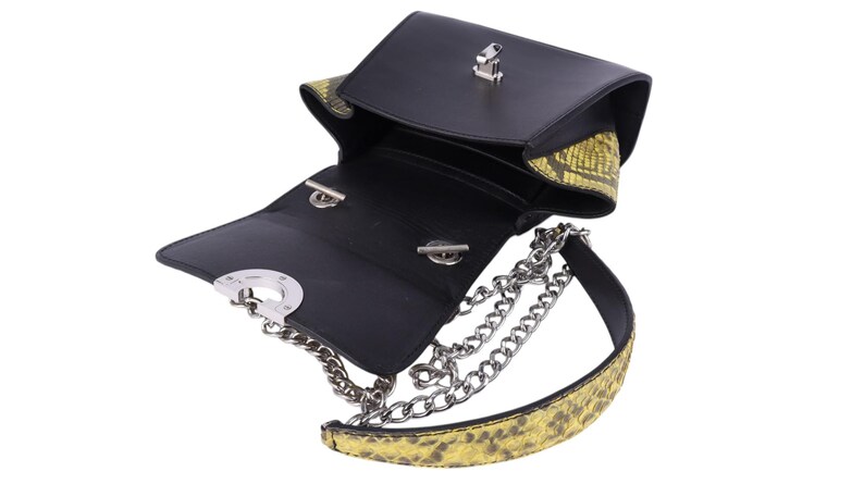 May include: Black leather crossbody bag with a silver chain strap and yellow snakeskin-patterned accents. The bag has a flap closure with a silver clasp and a structured design. The interior is black.