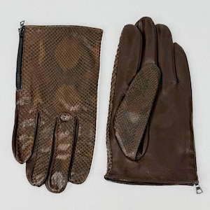 Peut inclure: Une paire de gants en cuir marron avec un motif peau de serpent. Un gant a une fermeture éclair noire sur le côté. L'autre gant est présenté avec la paume vers le haut, révélant le motif peau de serpent sur la paume.