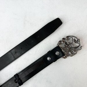 May include: A rustic wooden sign with the text "Welcome" in a handwritten style. The sign is painted white with a distressed finish, and features a decorative floral element in the corner. The background is a blurred image of a wooden surface.