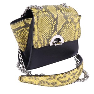 May include: A black and yellow crossbody bag with a snakeskin pattern on the flap and strap. The bag has a silver chain strap and a silver clasp. The bag is a stylish accessory.