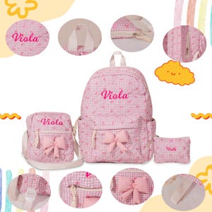 May include: A pink and white gingham backpack set with the name "Viola" embroidered on each piece. The set includes a backpack, a crossbody bag, and a small pouch, all adorned with bows.
