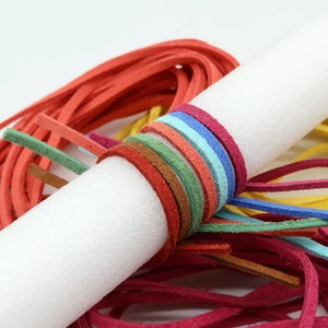 May include: Assortment of colorful leather cords wrapped around a white foam tube. The cords are in various shades of red, orange, yellow, green, blue, and brown.