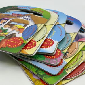 May include: A stack of eight colorful children's books with audio CDs. Each book features a different fairy tale, including "Snow White and the Seven Dwarfs". The books have a read-along feature and are designed for ages 3 and up.