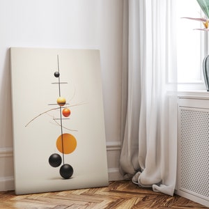 May include: A black metal sculpture with orange and yellow spheres hanging from it. The sculpture is on a white canvas and is set against a white wall.