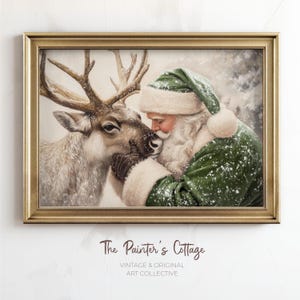 May include: A framed vintage print depicts Santa Claus in a green suit and hat, embracing a reindeer. The artwork has a gold frame and features the text "The Painter's Cottage, Vintage & Original Art Collective."