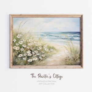May include: A painting of a beach scene with white daisies in the foreground, a sandy path leading to the ocean, and blue waves crashing on the shore.