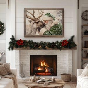 May include: A cozy living room scene with a fireplace, adorned with a Christmas wreath and garland. A framed artwork depicts Santa Claus and a reindeer. The room is decorated in neutral tones, creating a warm and inviting holiday atmosphere.