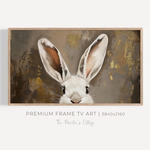 Può includere: Un coniglio bianco con grandi orecchie spunta da dietro uno sfondo testurizzato marrone e dorato. Gli occhi del coniglio sono neri e il suo naso è rosa. Lo sfondo ha un leggero bagliore dorato.