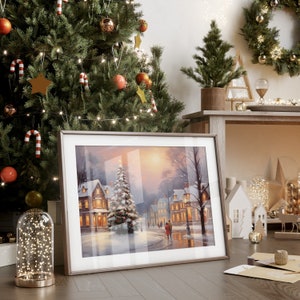 Puede incluir: Una pintura de invierno enmarcada con un pueblo nevado, un &aacute;rbol de Navidad y dos personas caminando en la distancia. La pintura est&aacute; colgada en una pared junto a un &aacute;rbol de Navidad decorado con adornos y luces.