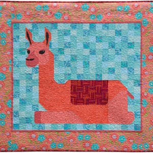 May include: A red and pink llama with a purple and red saddle, lying down on a blue and green checkered background with a pink floral border.