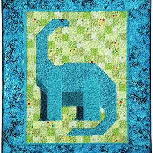May include: A blue and green patchwork quilt featuring a large blue dinosaur in the center. The dinosaur is outlined in black and has a white eye. The quilt is surrounded by a blue border with a white floral pattern.