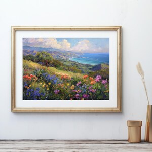 Pu&ograve; includere: Un dipinto di un paesaggio costiero con vista sull'oceano da una collina ricoperta di fiori selvatici. I fiori sono in tonalit&agrave; di rosa, viola, giallo e arancio. L'oceano &egrave; di un blu profondo e il cielo &egrave; di un azzurro chiaro con nuvole bianche.