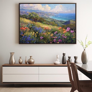 Pu&ograve; includere: Un dipinto di un paesaggio costiero con vista su un oceano blu e colline verdi. In primo piano, un campo di fiori selvatici colorati in tonalit&agrave; di viola, rosa, giallo e rosso.