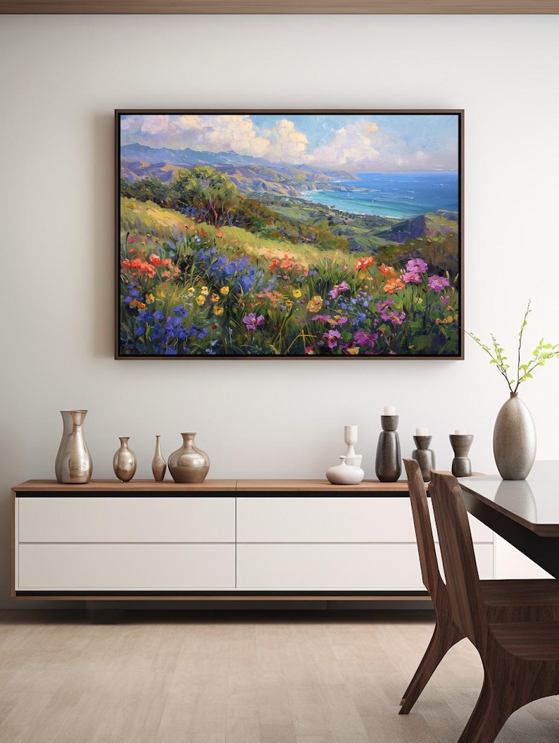 Pu&ograve; includere: Un dipinto di un paesaggio costiero con vista su un oceano blu e colline verdi. In primo piano, un campo di fiori selvatici colorati in tonalit&agrave; di viola, rosa, giallo e rosso.