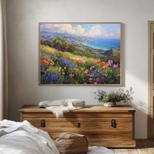 Pu&ograve; includere: Un dipinto che rappresenta un paesaggio costiero con vista sull'oceano e un campo di fiori selvatici in tonalit&agrave; di viola, rosa, giallo e arancio.