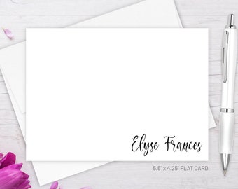 May include: White flat card with the text "Elyse Frances" and the dimensions "5.5" x 4.25" FLAT CARD". The card is on a white wooden surface with pink flowers and petals.