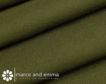 May include: Close-up of a dark green fabric with a subtle herringbone weave. The fabric is folded in thirds, creating a textured surface. The text "marce and emma a little of everything" is visible at the bottom of the image.