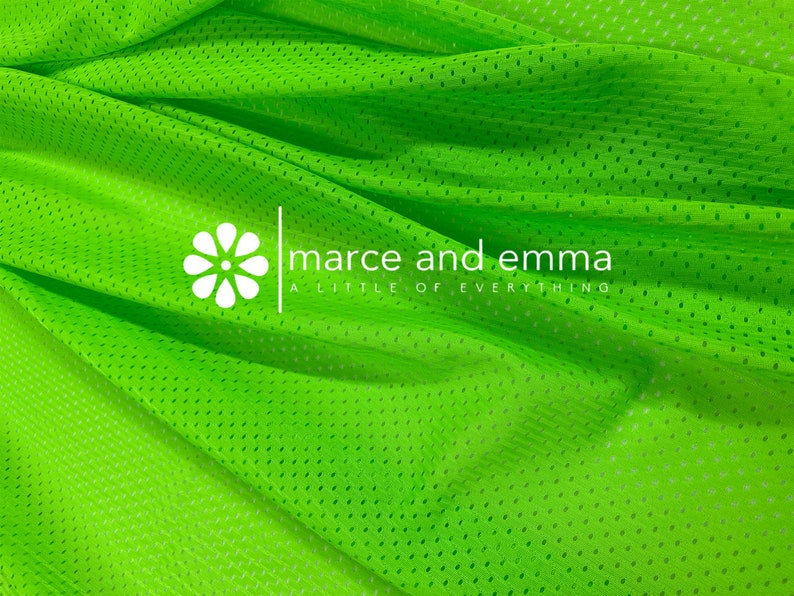 May include: Bright green mesh fabric with a small, white flower and the text "marce and emma a little of everything" printed on it.