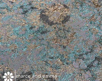 May include: Teal and gold brocade fabric with a textured, abstract pattern. The fabric has a subtle sheen and a luxurious feel.