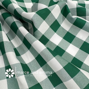 May include: Green and white checkered fabric with a subtle texture. The fabric is folded and draped, showcasing the pattern.