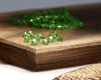 Bead, glass, spring green, 7x5mm-8x6mm faceted teardrop. Sold per pkg of 50.