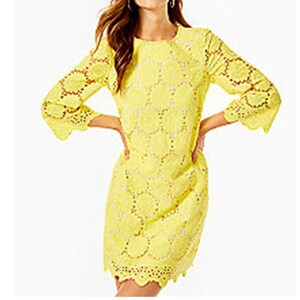 May include: A yellow eyelet dress with a round neckline and 3/4 sleeves. The dress has a scalloped hem and a delicate floral pattern.