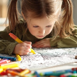Può includere: Una bambina con i capelli biondi raccolti in due codini è concentrata a colorare un'illustrazione in bianco e nero con un pennarello giallo. Una collezione di pennarelli e pastelli colorati è sparsa intorno al libro da colorare.
