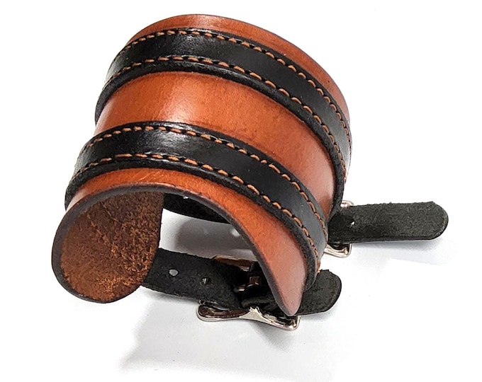 Hand crafted tan leather wrist cuff with 2 black leather straps.