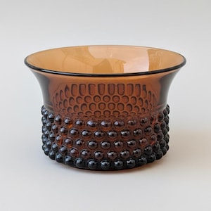 Può includere: Una tazza di ceramica bianca con un manico nero e la scritta "But First, Coffee" in stile scritto a mano. La tazza è su una superficie bianca. La tazza è alta circa 10 cm.