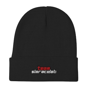 May include: A black beanie with a folded brim. The beanie has the embroidered text "team simracelab" in red and white. The hat is made of a soft, knitted material.