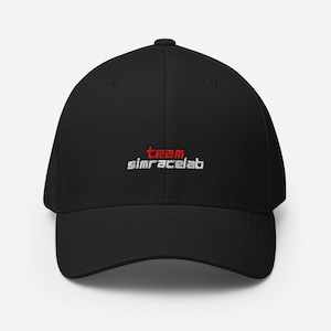 May include: Black baseball cap with a curved brim. The cap features the text "team simracelab" embroidered in red and white thread across the front. The hat is made of a durable fabric and has a structured fit.