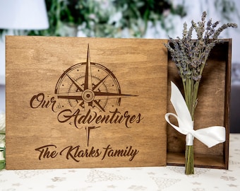 May include: A wooden box with a compass design and the text "Our Adventures The Klarks Family" engraved on the lid. The box is open and a bundle of dried lavender is inside.