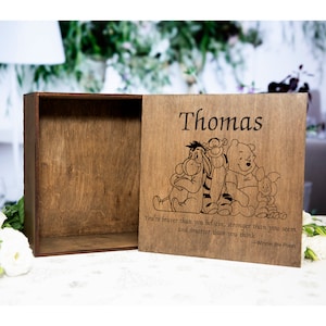 May include: A wooden box with a sliding lid, engraved with the name "Thomas" and a Winnie the Pooh illustration. The lid also features the quote "You're braver than you believe, stronger than you seem and smarter than you think - Winnie the Pooh."