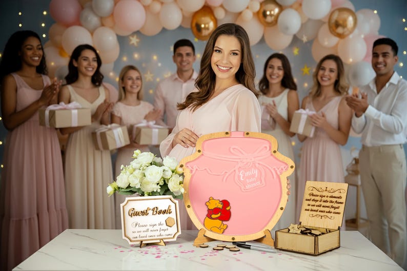 May include: A pink Winnie the Pooh themed guest book with the name "Emily" engraved on it. The guest book is surrounded by a group of people at a baby shower. A sign that says "Guest Book" is also on the table.