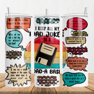 May include: A white tumbler with a colorful retro design featuring a floppy disk and the text "I keep all my dad jokes in a dad-a-basic". The tumbler is decorated with speech bubbles containing various dad jokes.