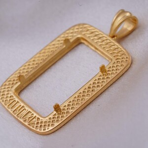 May include: A gold-colored rectangular pendant with a textured, diamond-patterned frame. The pendant has a loop at the top for a chain and two small prongs inside the frame. The pendant is likely for jewelry making.