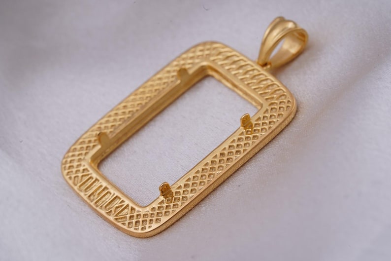 May include: A gold-colored rectangular pendant with a textured, diamond-patterned frame. The pendant has a loop at the top for a chain and two small prongs inside the frame. The pendant is likely for jewelry making.