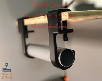 Può includere: Un morsetto nero con un tubo bianco attaccato ad esso. Il morsetto è attaccato a una superficie di legno. Il testo "Download digitale" è visibile nell'immagine.