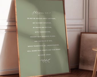 Puede incluir: Una impresión enmarcada con un fondo verde salvia y un marco de madera. La impresión presenta un elegante texto blanco de Filipenses 4:6-7, que ofrece un mensaje de fe y paz. Una ramita decorativa de hojas está en la parte inferior.