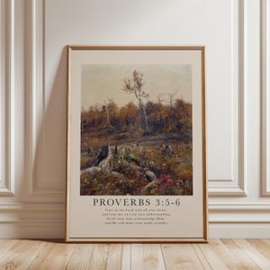 May include: A framed art print displaying a landscape painting of a forest scene in autumnal hues. The artwork shows a light sky and a foreground with tree stumps and wildflowers. The text "PROVERBS 3:5-6" and a related verse are printed at the bottom.