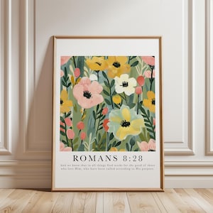 Könnte beinhalten: Gerahmter Kunstdruck mit einem floralen Muster in Gelb, Rosa und Grün. Der Druck enthält den Text "ROMANS 8:28" und einen Bibelvers. Das Kunstwerk wird in einem goldenen Rahmen präsentiert. Geeignet für die Inneneinrichtung.
