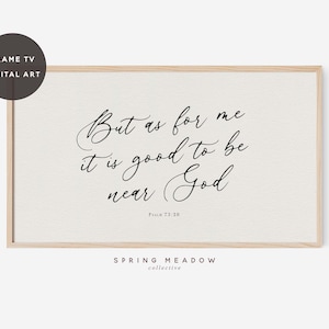May include: A white framed print with a black calligraphy quote: "But as for me it is good to be near God." The quote is from Psalm 73:28. The print has the text "SPRING MEADOW collective" at the bottom.