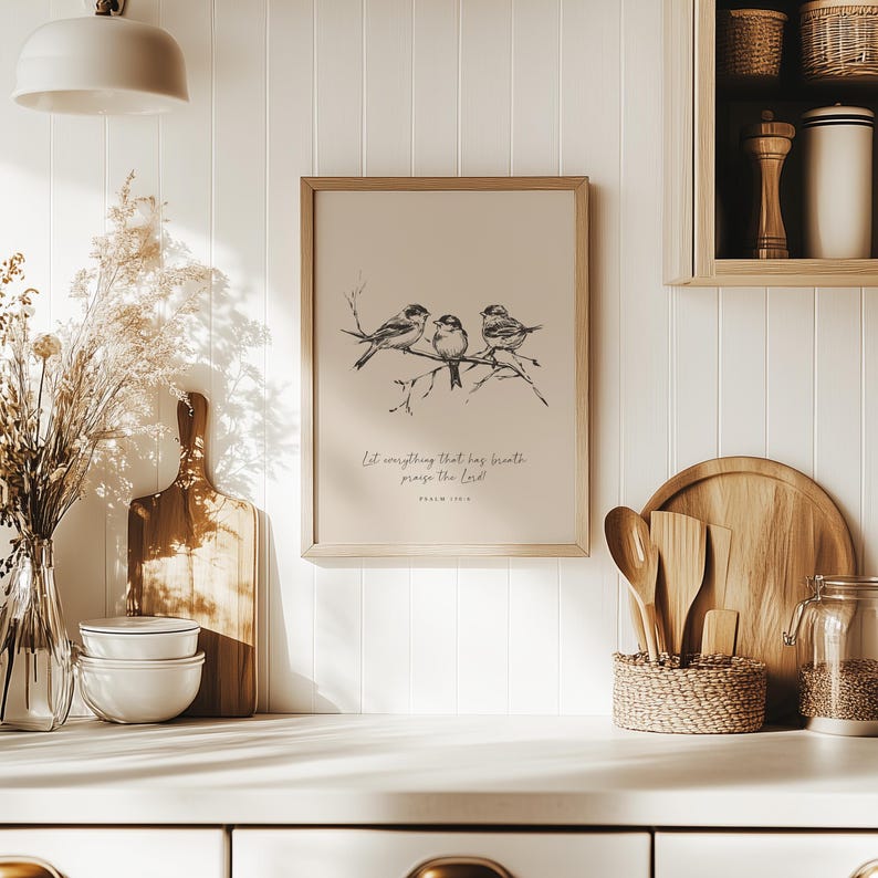 May include: A framed print featuring three birds perched on a branch, rendered in black and white. The print includes the text "Let everything that has breath praise the Lord!" in a script font. The frame is light brown.