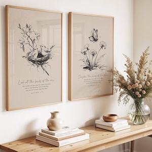 May include: Two framed art prints with botanical illustrations and text. One shows birds in a nest with the text "Look at the birds of the air." The other features a butterfly and flowers with the text "Consider the lilies of the field."