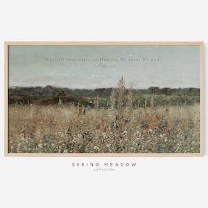 Puede incluir: Una impresión enmarcada que presenta un paisaje rural con un campo de flores silvestres y una línea de árboles distante bajo un cielo apagado. Se muestra el texto "Cast all your cares on Him for He cares for you. 1 Peter 5:7". Las palabras "SPRING MEADOW collective" están en la parte inferior.