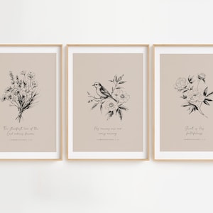 May include: Three framed art prints with botanical illustrations. Each print features a different floral or bird design in black ink on a beige background. The prints include inspirational text in a script font.