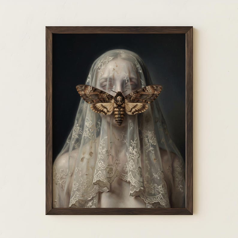 May include: A framed artwork featuring a person veiled in white lace, with a large moth covering the face. The moth has brown and tan wings with a skull-like marking. The artwork has a dark background and a brown wooden frame.