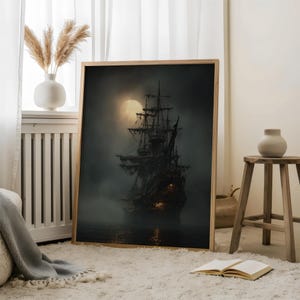May include: A framed print of a ghostly pirate ship sailing on dark waters under a full moon. The ship is silhouetted against the moon, with details of the masts and rigging visible. The artwork is in a wooden frame.