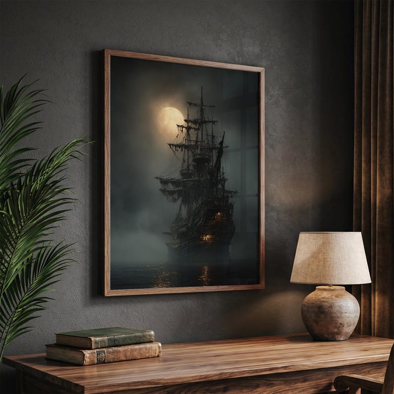 May include: A framed print of a ghostly pirate ship sailing on dark waters under a full moon. The ship is silhouetted against the moon, with tattered sails and glowing lights. The print is in a wooden frame, displayed on a wooden desk.